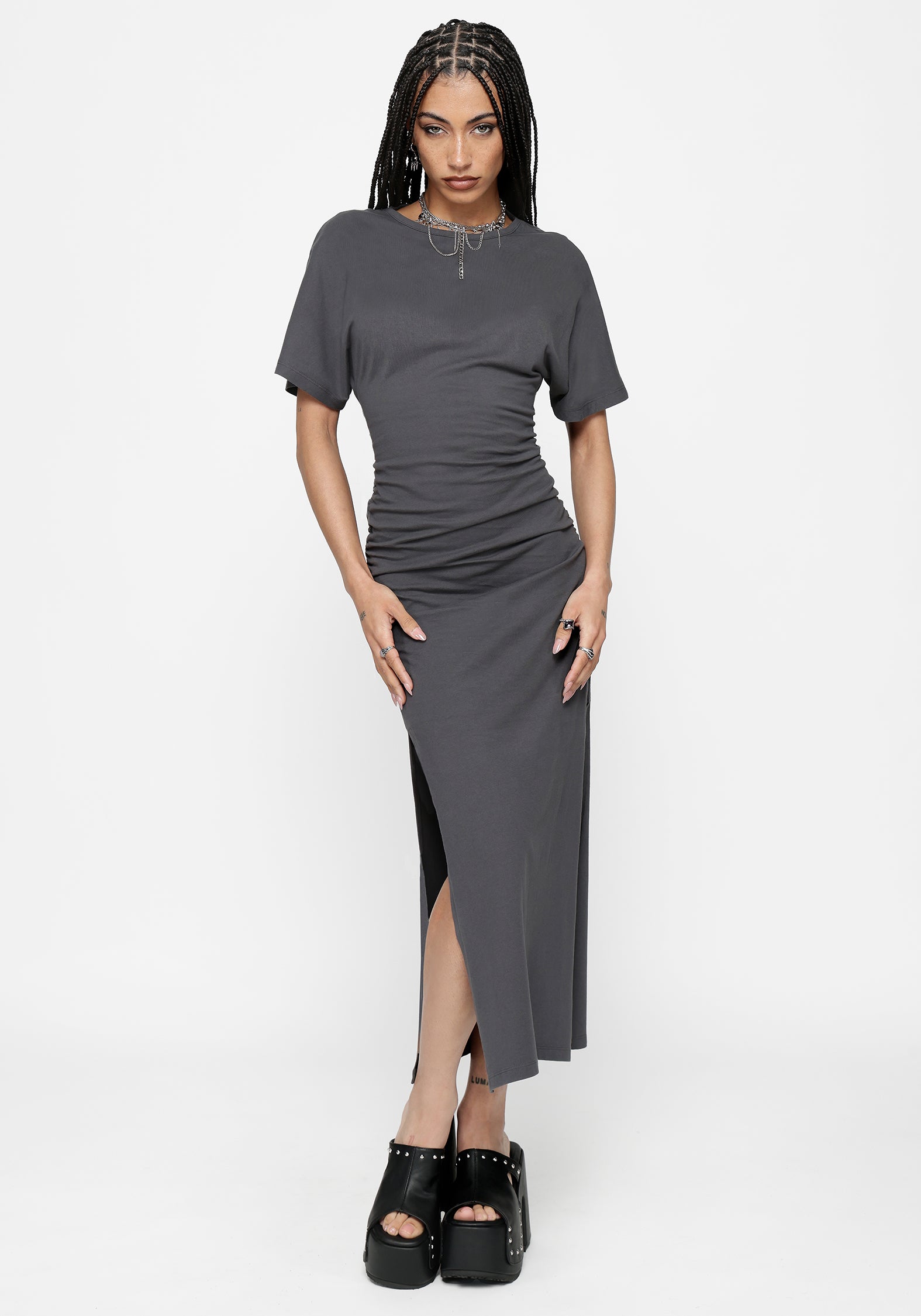 Woman wearing a grey midaxi dress with a thigh slit on a white background