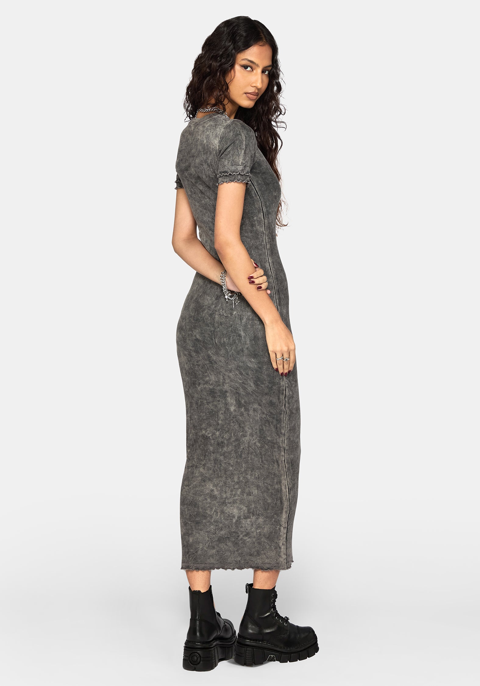 A woman modeling a short-sleeve, acid-wash gray maxi dress with a textured, faded finish, paired with black platform ankle boots against a light gray studio background.