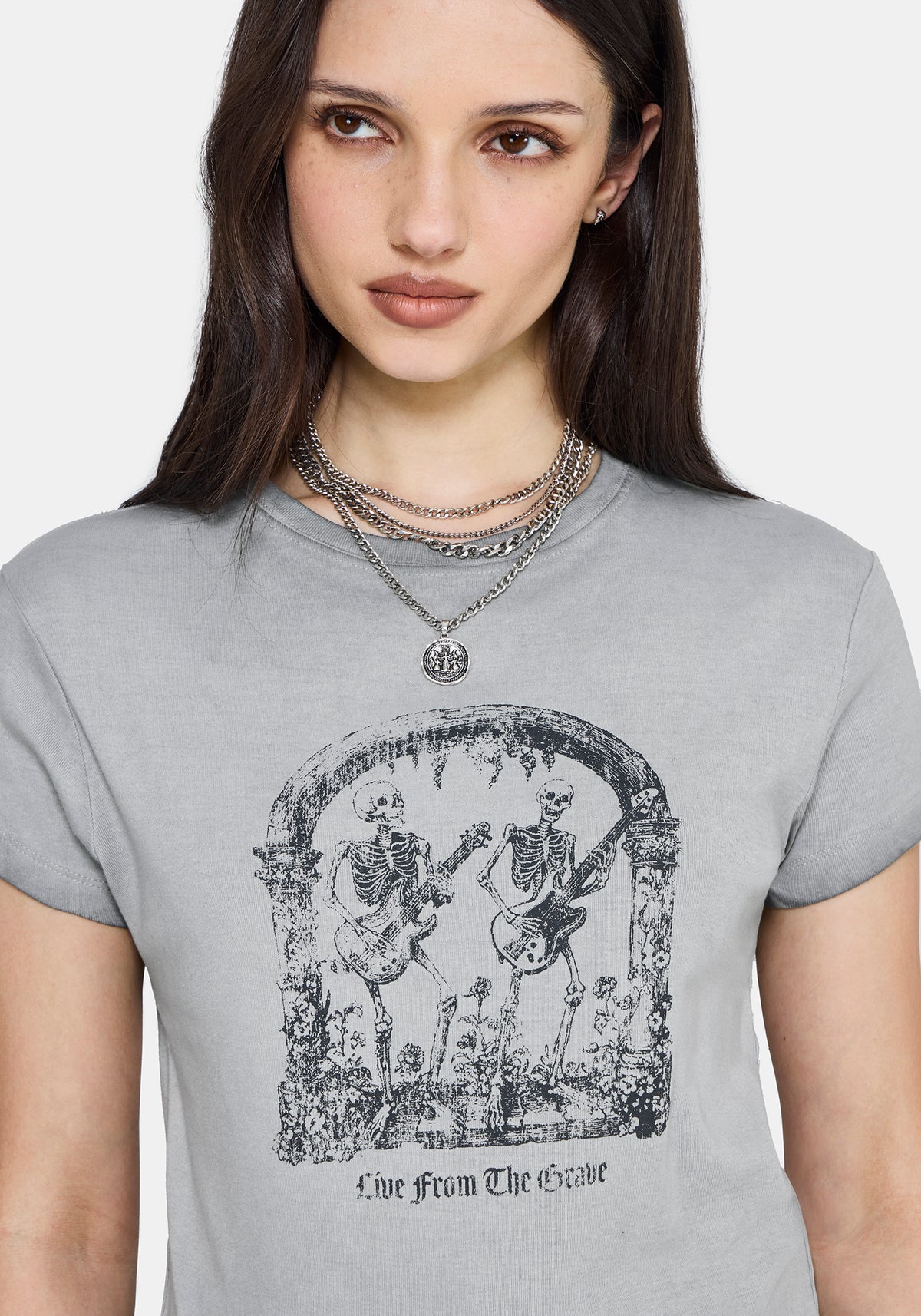 Woman wearing a gray t-shirt with a graphic design and text.
