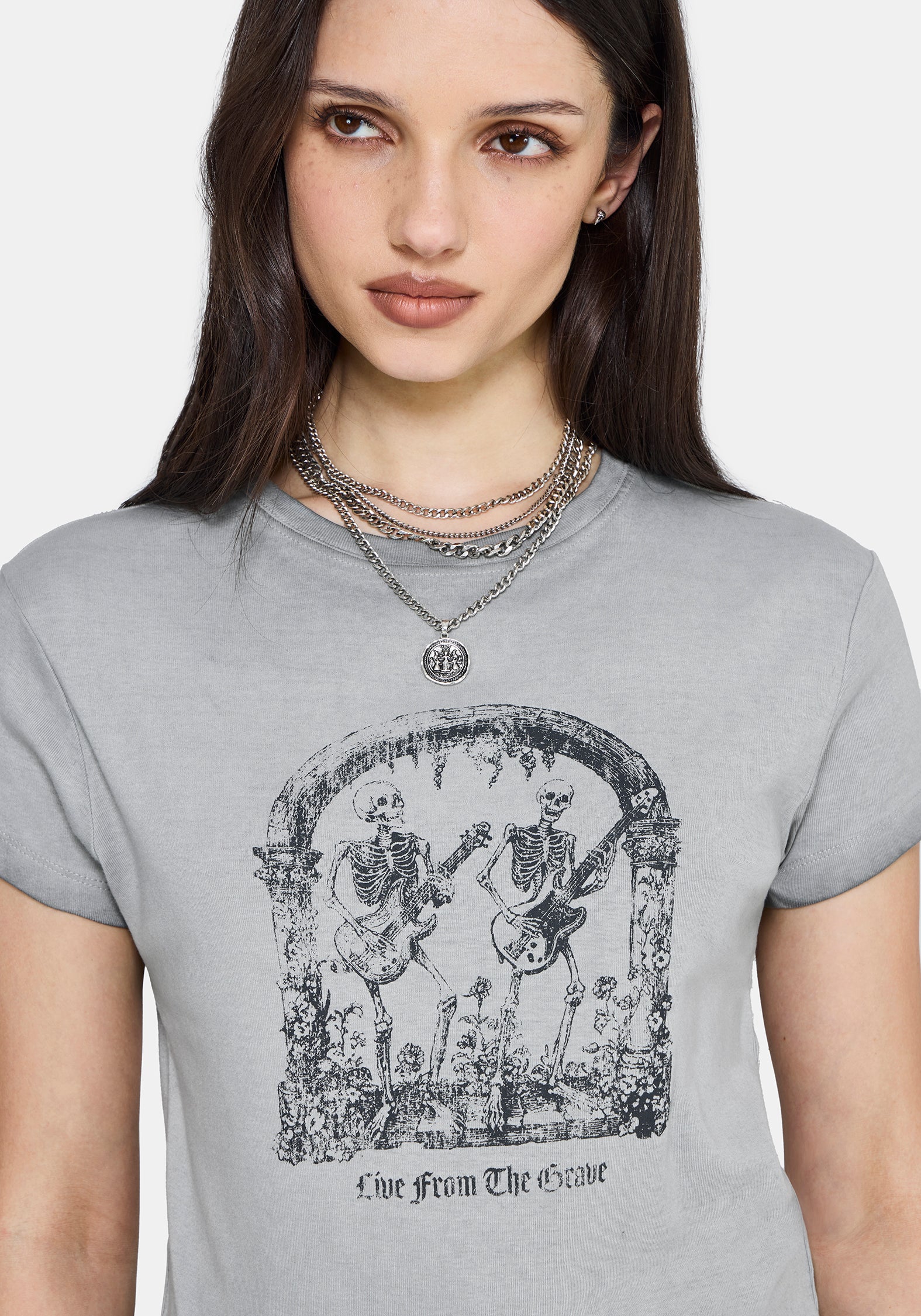 Woman wearing a gray t-shirt with a graphic design and text.