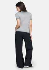 Woman wearing a gray t-shirt and black pants on a white background